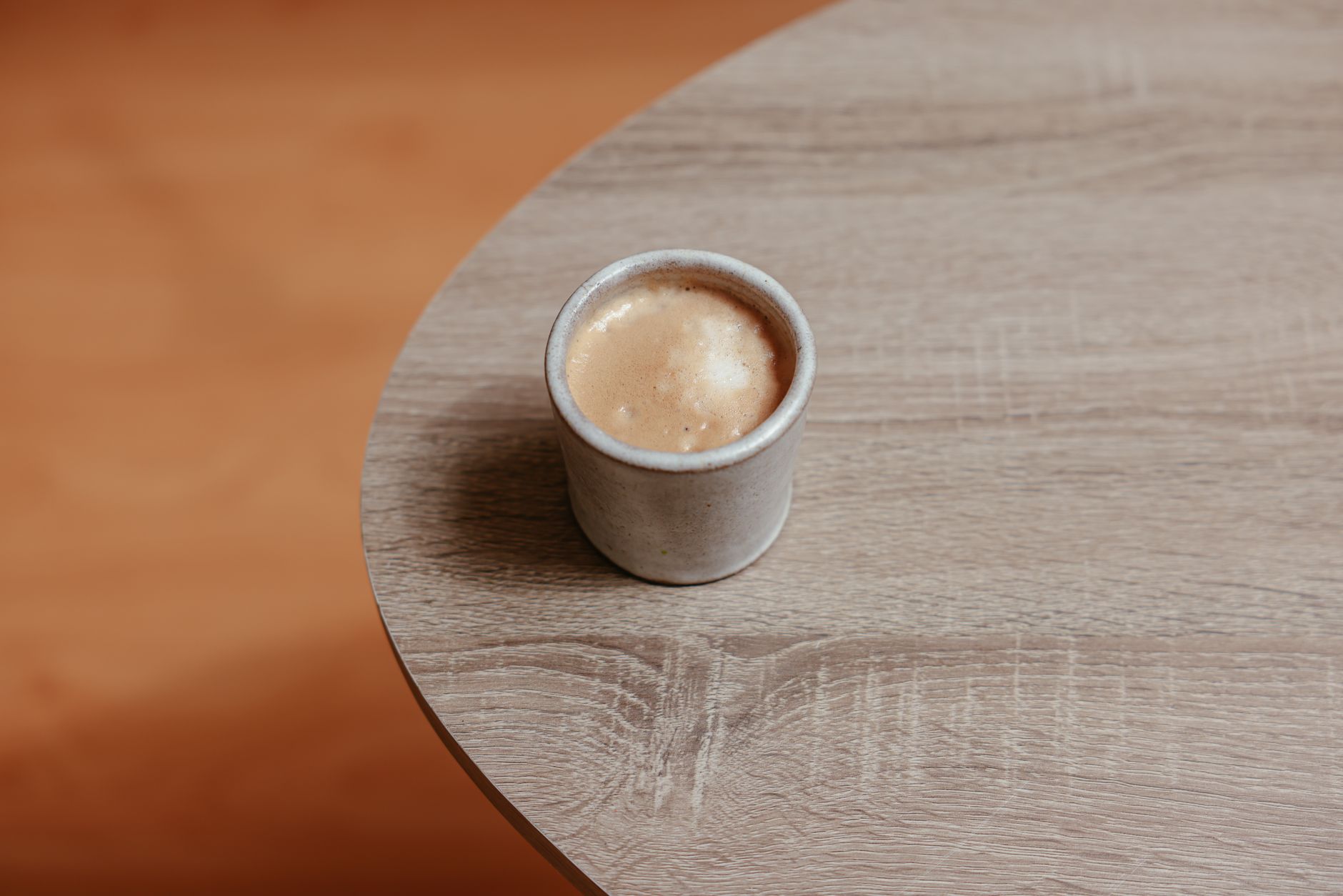 Ahşap masa üzerinde duran şık ve minimalist tasarımlı seramik kupa