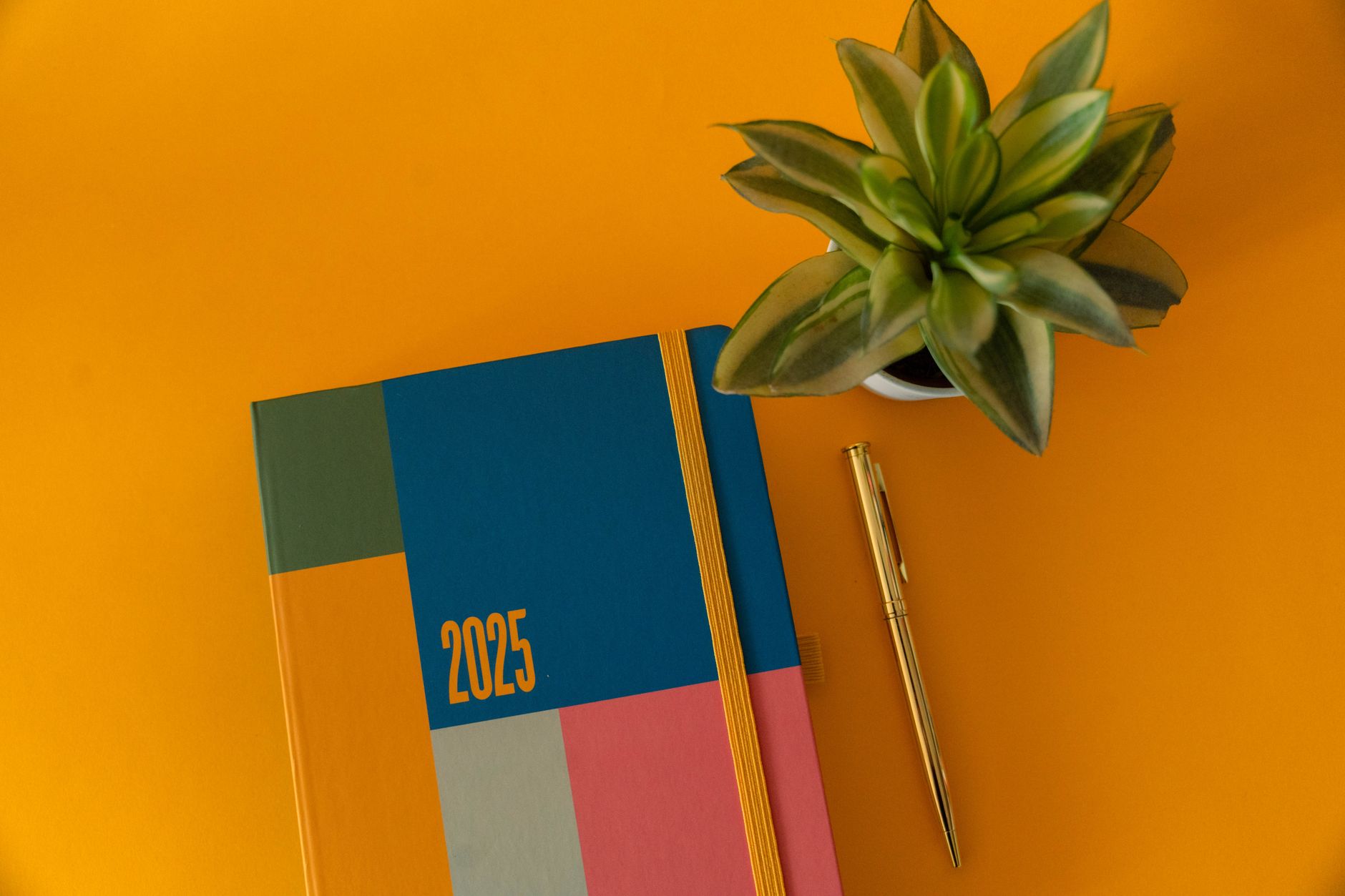 Ahşap masa üzerinde estetik planlayıcı defter ve renkli kalemler