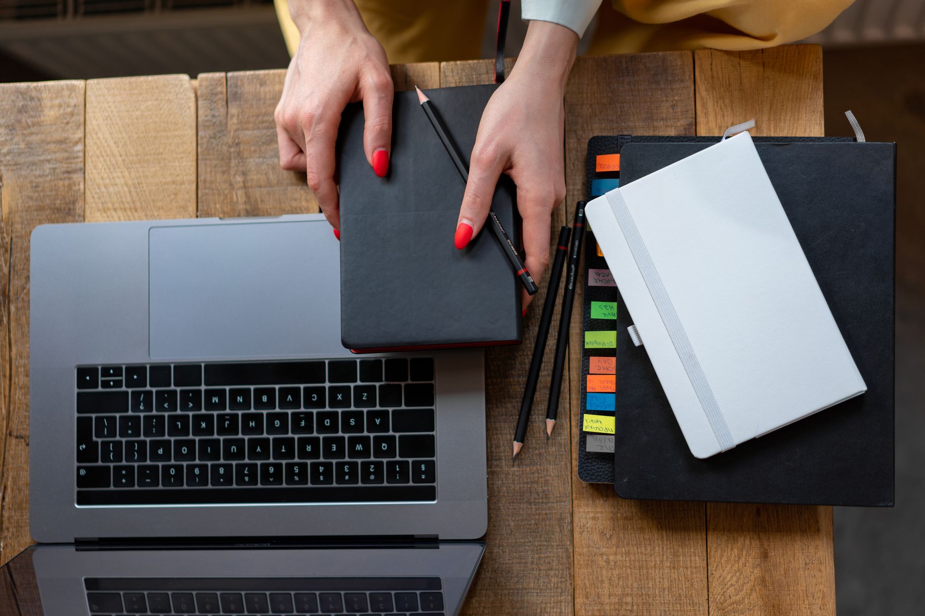 An elegant leather planner notebook with a pen on a wooden desk